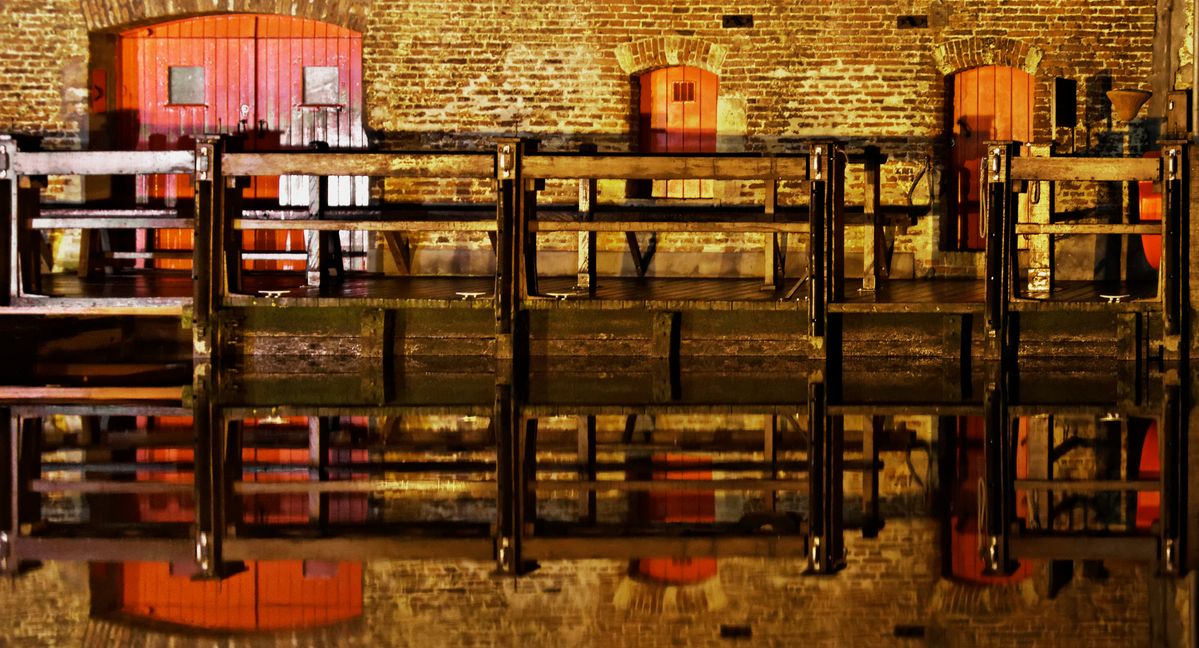 Still water relecting a jetty alongside a canal in Brugge