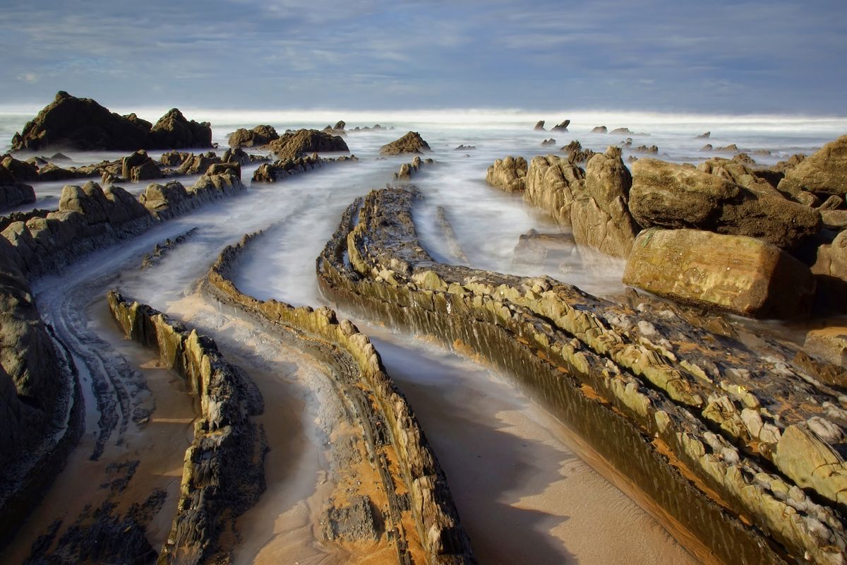 En la playa de Barrika, en Bizkaia en el Pais Vasco, el agua juega entre las rocas y utilizando un filtro neutro saque esta foto. Lo que buscaba es que las rocas parecieran una Colas de Dragón entrando en el mar.r.n 