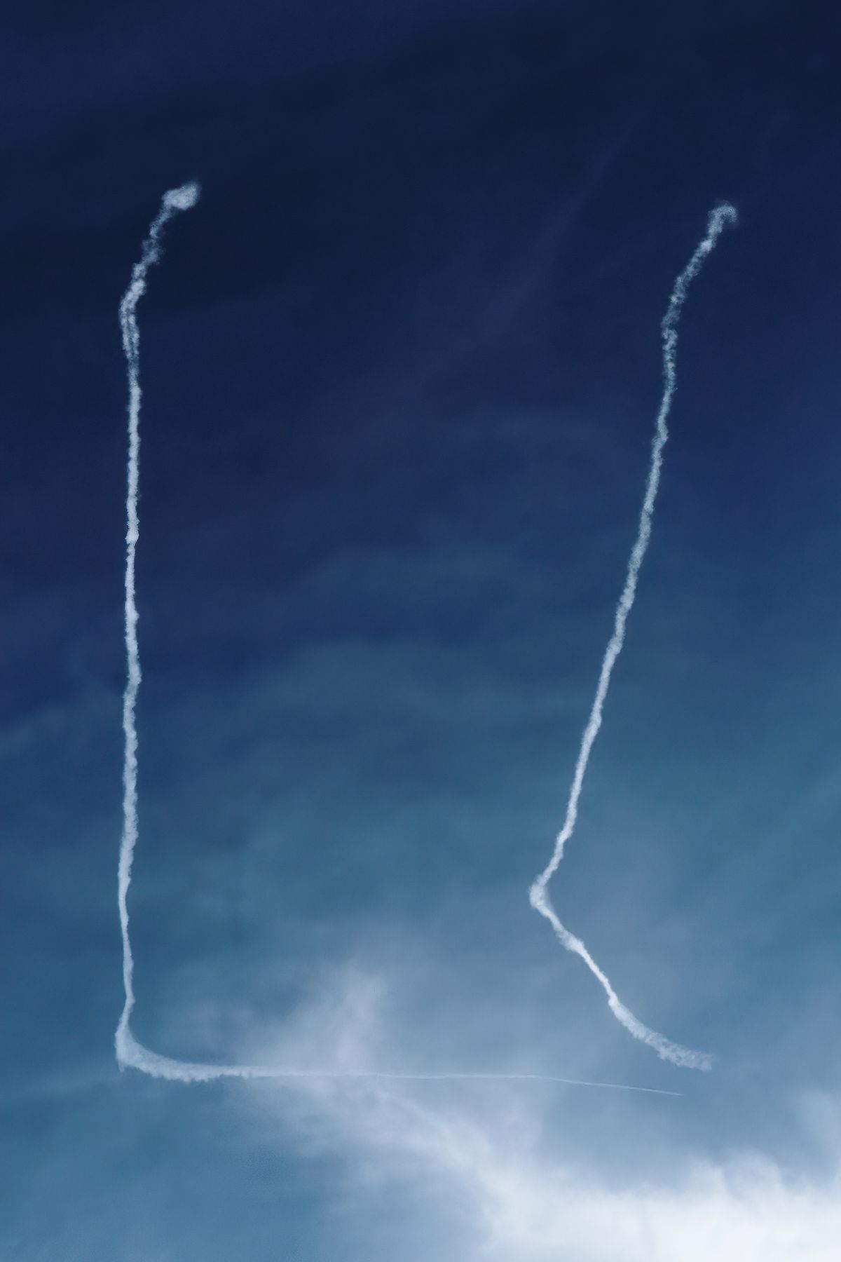 Zwei Flugzeuge zeichnen mit Kondensstreifen ein U am Himmel