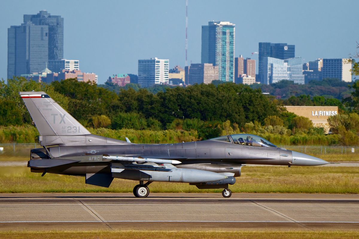 Spads ist der Nickname für das 457th Fighter Squadron, das auf der NAS Fort Worth - JRB Carswell Field beheimatet ist. Landung der 86-0231 / TX F-16C "Fighting Falcon" 457th FS AFRC, mit der Skyline von Fort Worth in Texas in Bildhintergrund.