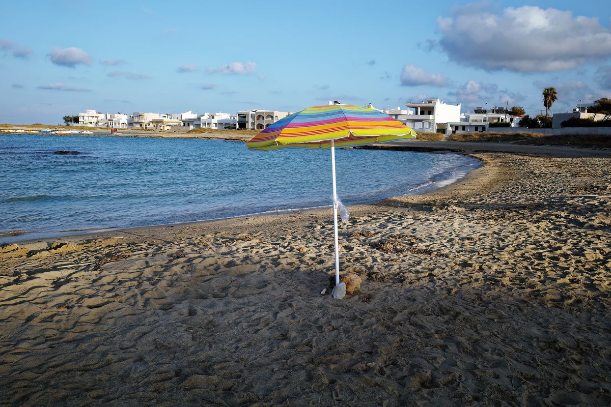 Ein verwaister Sonnenschirm, auf dem Zentralen Sandstrand von Torre Santa Sabina